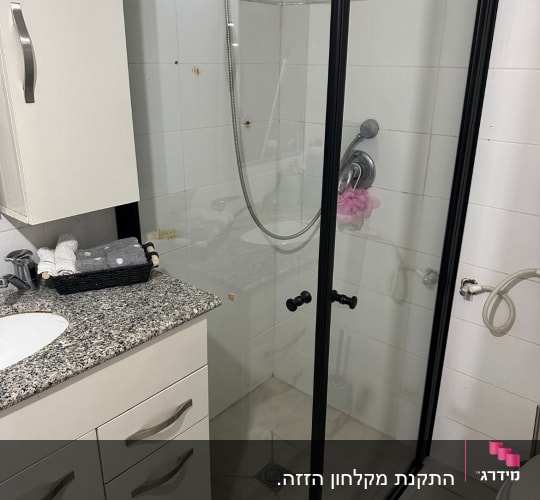 מקלחון זכוכית עם ראש מקלחת מתכתי